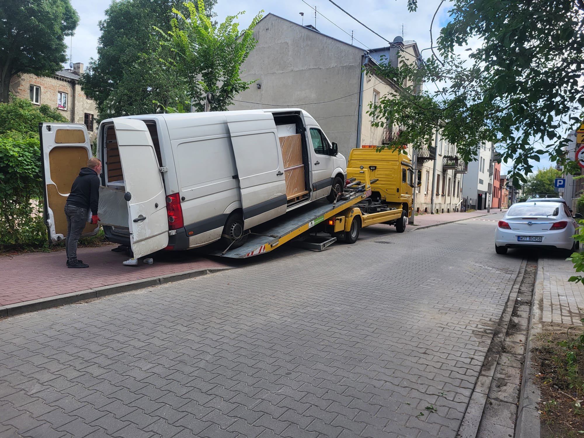 Holowanie busa dostawczego – załadunek na lawetę w centrum miasta